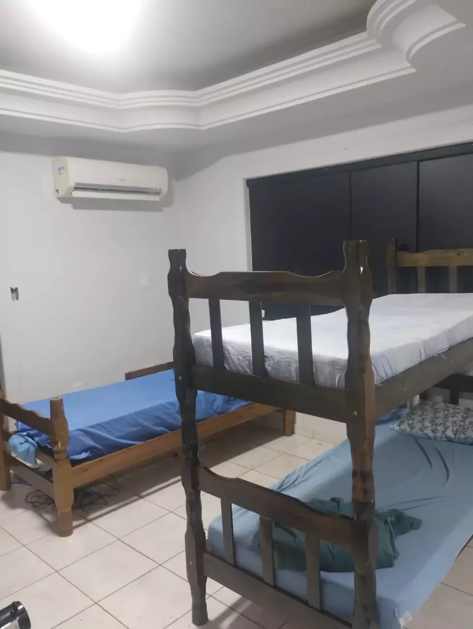 Quarto com beliches, roupa de cama limpa e ar-condicionado em clínica de recuperação