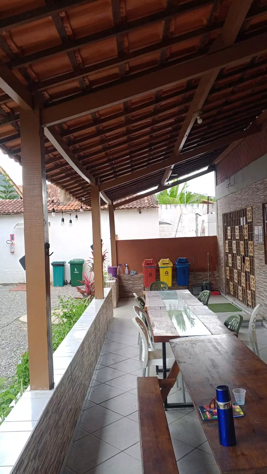 Refeitório coberto com mesas comunitárias em clínica de recuperação